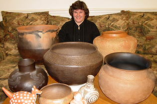 a woman with several pieces of pottery